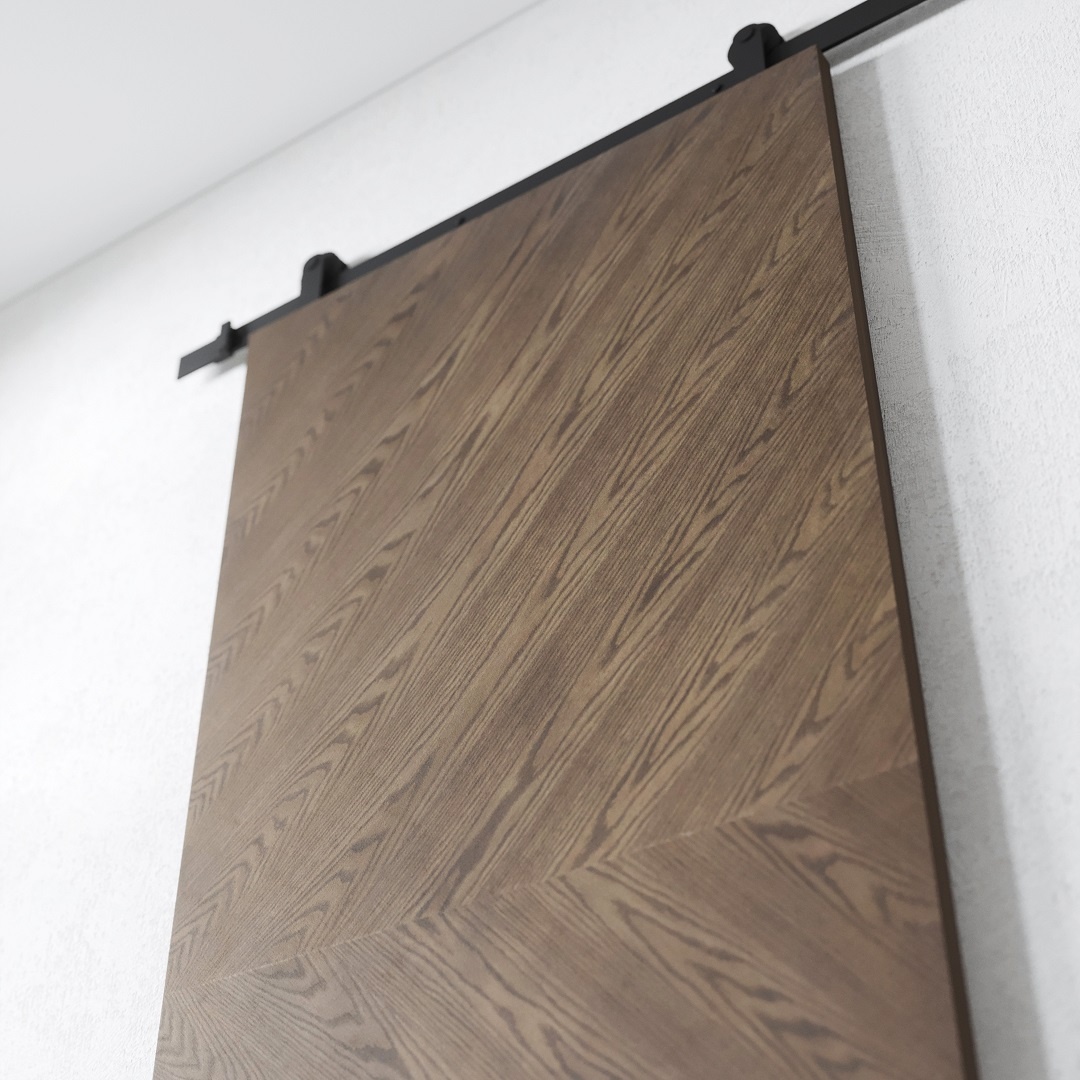 BIANCO - DARK 2 A Bianco, Dark Barn Door (83" x 40") with a chevron pattern is mounted on a black metal rail against a white wall.