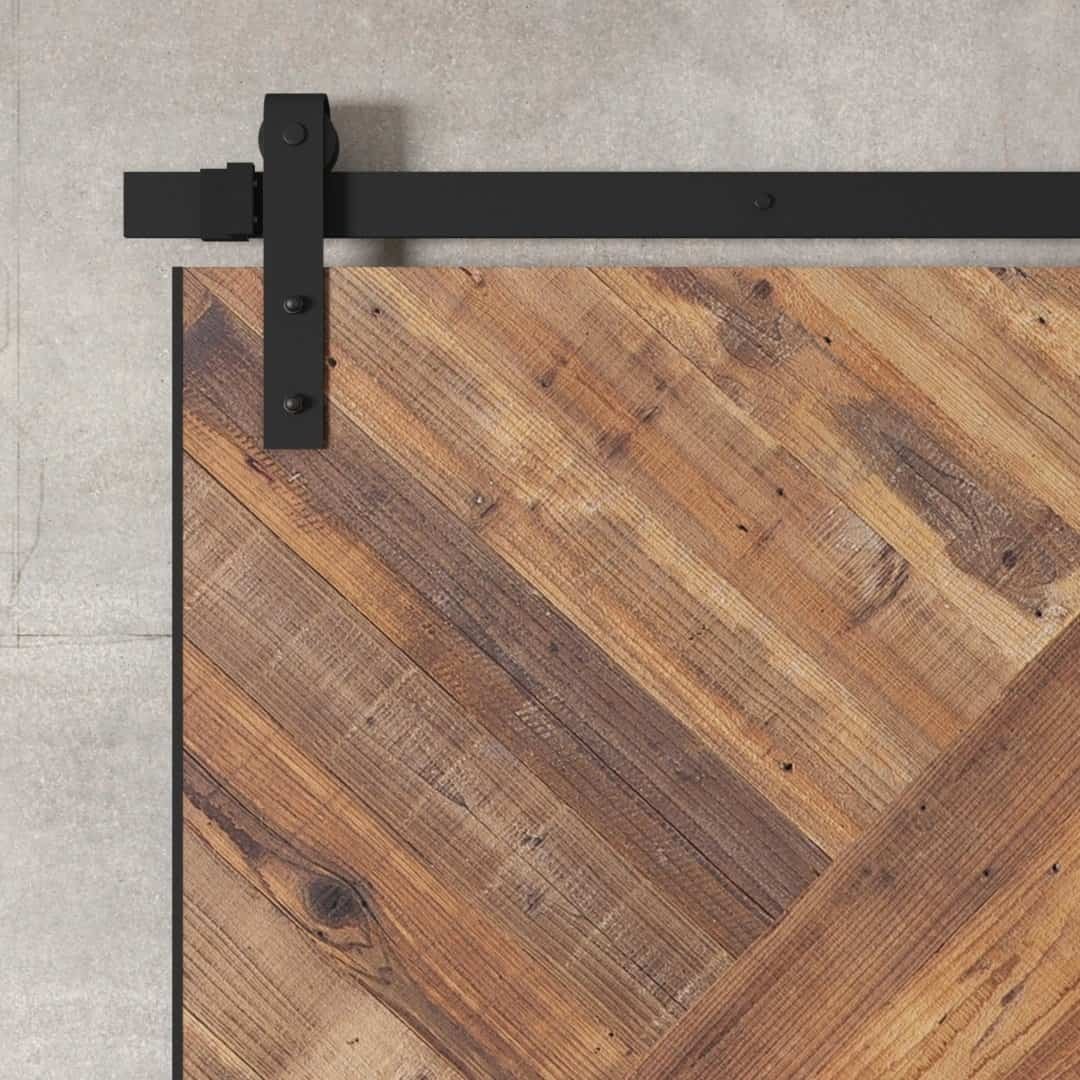 Urban Woodcraft Malibu Barn Door - Natural (4) Close-up of the Malibu, a sliding barn door made from reclaimed wood with a plank design and black metal hardware, set against a textured gray wall.