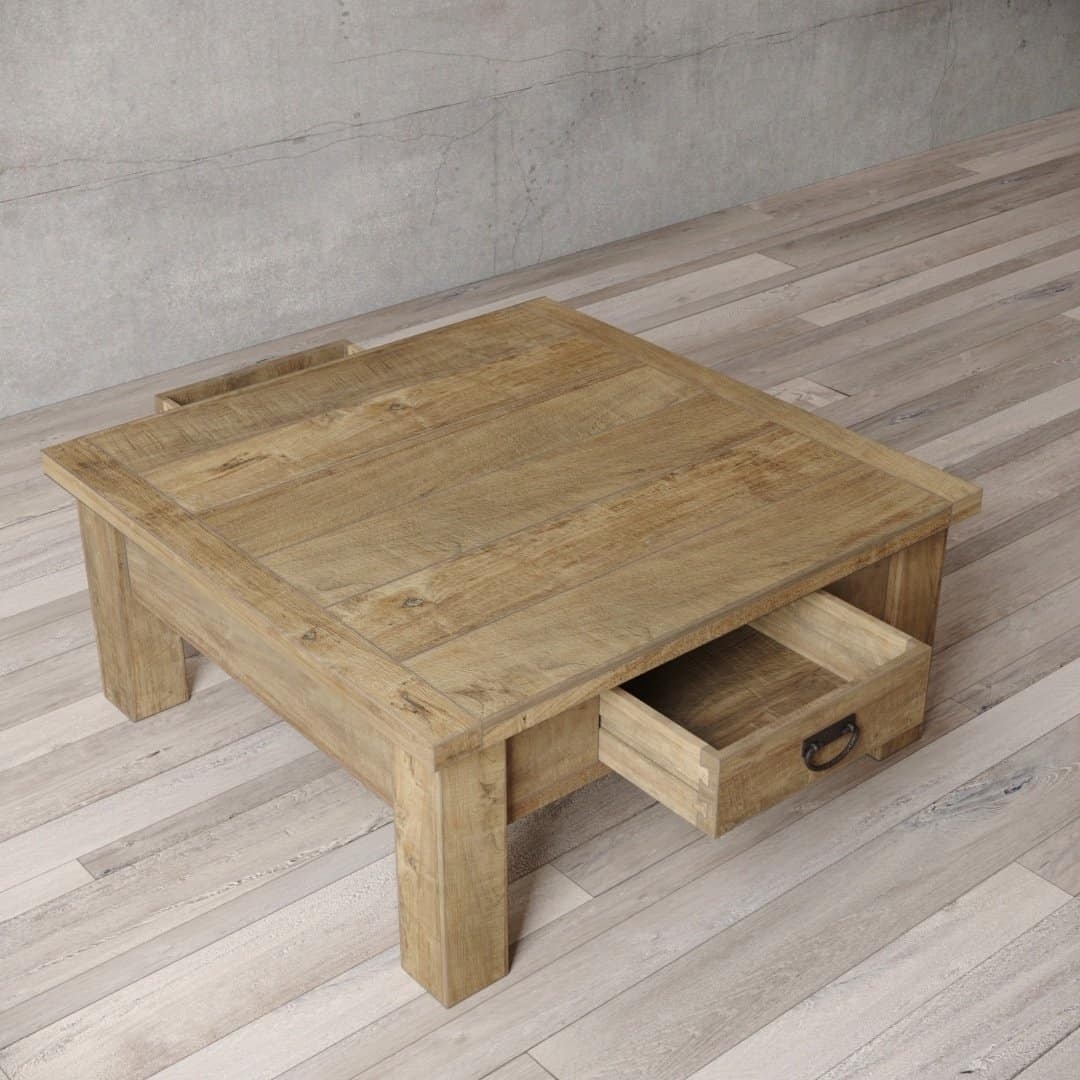 Urban Woodcraft 40 Riverbend Coffee Table - Natural (5) The Riverbend Coffee Table, a square wooden piece with thick legs and a small drawer partially pulled out on one side, is placed on a light wooden floor.