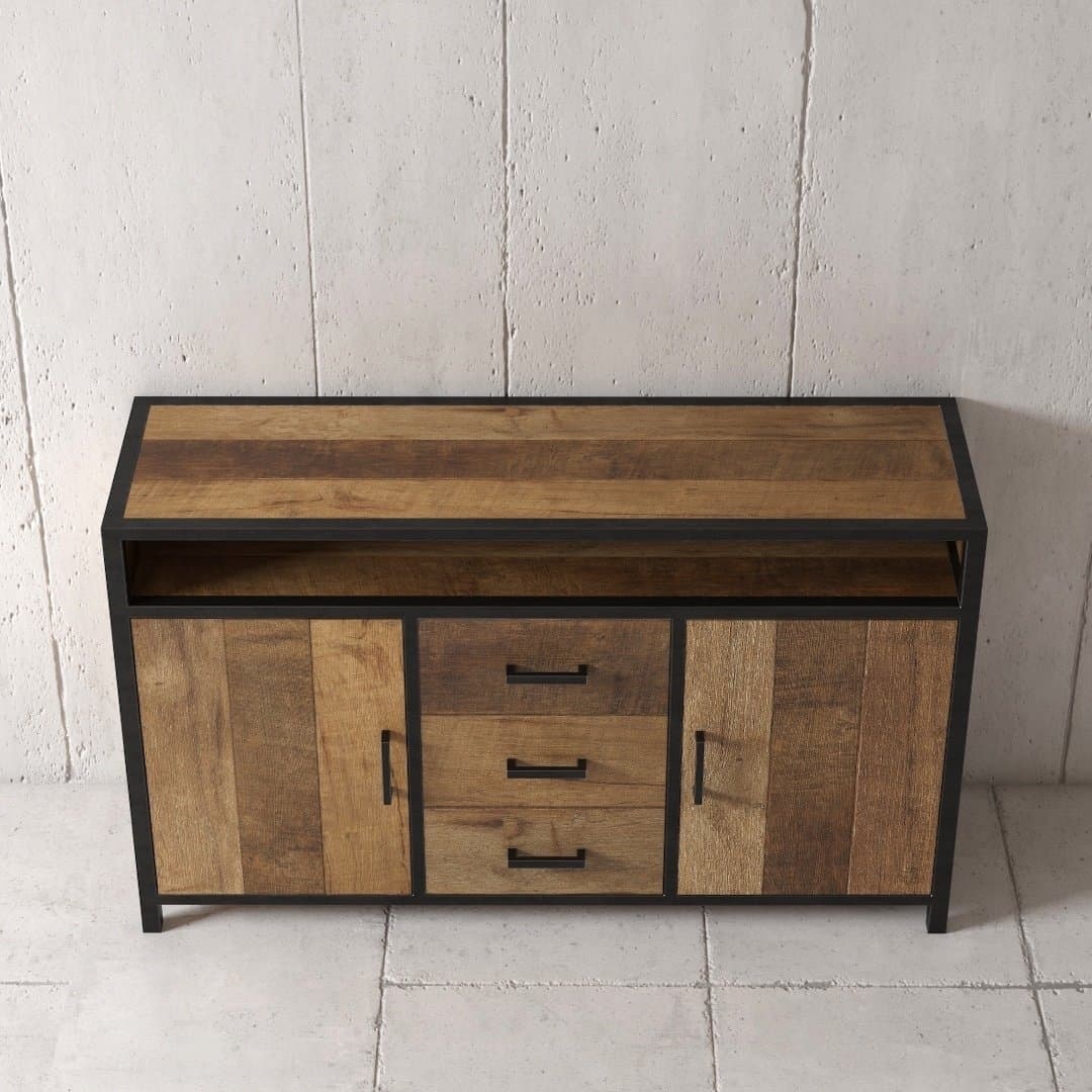 Urban Woodcraft 60 Opus Dining Buffet - MultiColoured Teak (3) The Opus Dining Buffet, a stylish wooden sideboard with a black frame, features three central drawers and two cabinets, standing elegantly against a concrete wall.