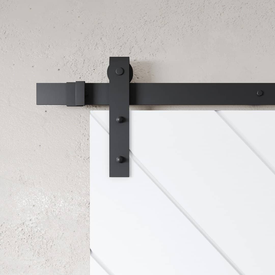 PRESTIGE WHITE (3) A close-up of the Prestige white barn door (83" x 40"), featuring a black metal rail and hardware, against a textured light gray wall.