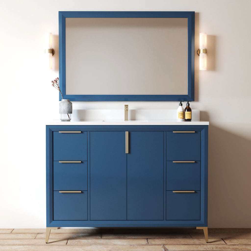The Mendocino 48" Single Sink Bathroom Vanity features a large blue cabinet, a white countertop, and a rectangular mirror. Two wall-mounted lights are positioned on either side of the mirror, illuminating the sink and toiletries that rest on the countertop.