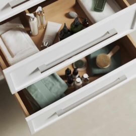 Open drawers in the Barrington 48" Single Sink Bathroom Vanity, neatly organized with skincare and grooming products, including bottles, towels, and a brush.
