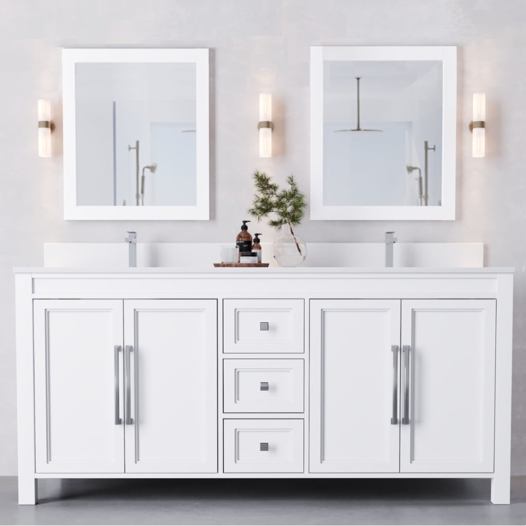 A modern bathroom vanity with two sinks, two mirrors, and overhead light fixtures. The counter has a small decor plant and grooming items.