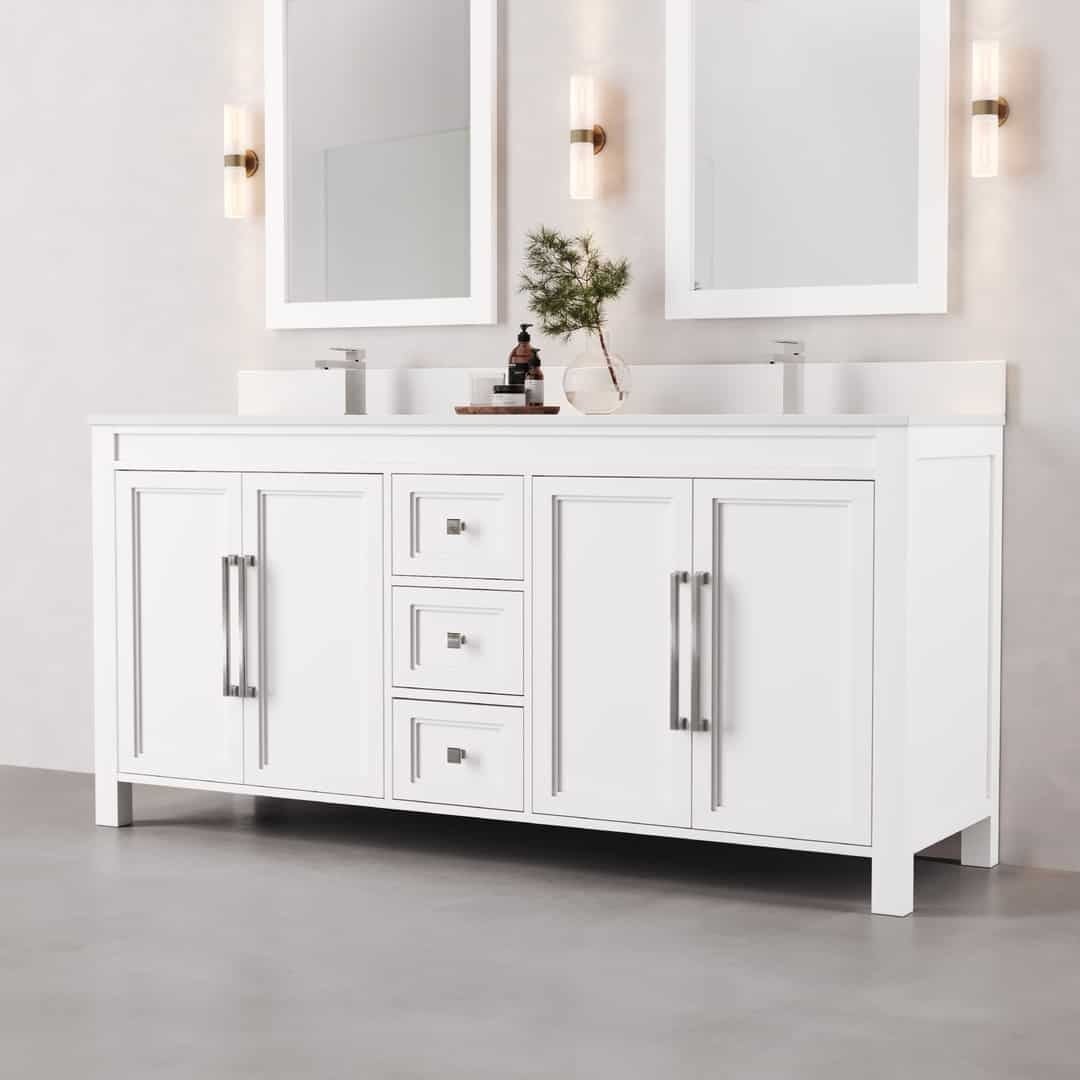 72_ Double Sink Belluno Vanity (White) - 2 The Belluno 72" Double Sink Vanity features dual sinks, white cabinetry with mirrors, ambient side lighting, and spacious cabinet storage beneath. It is elegantly topped with a small plant and a sleek bottle, set against a grey floor and light-colored walls for a sophisticated bathroom aesthetic.