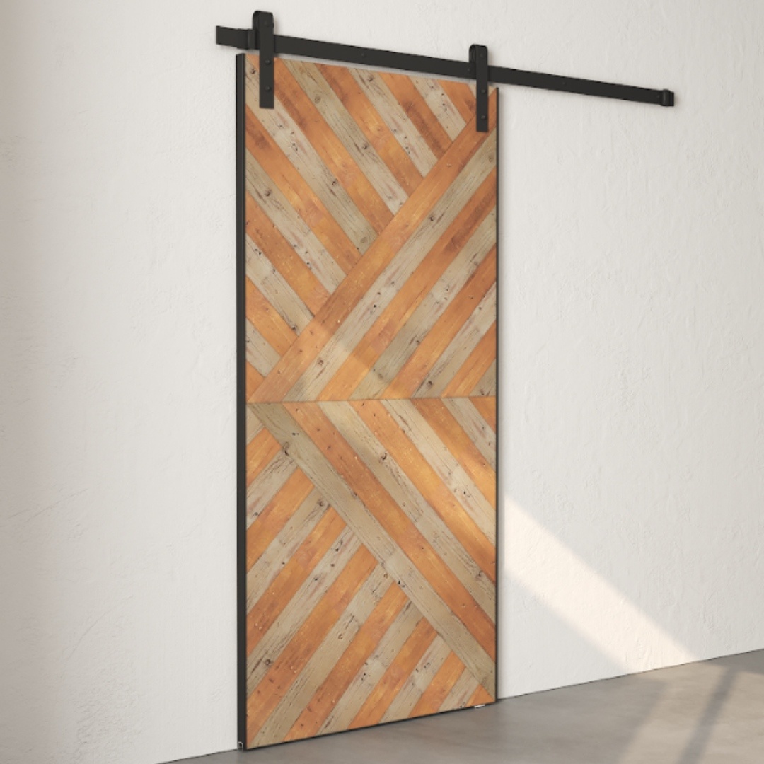 The Celestia Reclaimed Wood Barn Door in grey, featuring a chevron pattern, is mounted on a black metal track against a plain white wall.