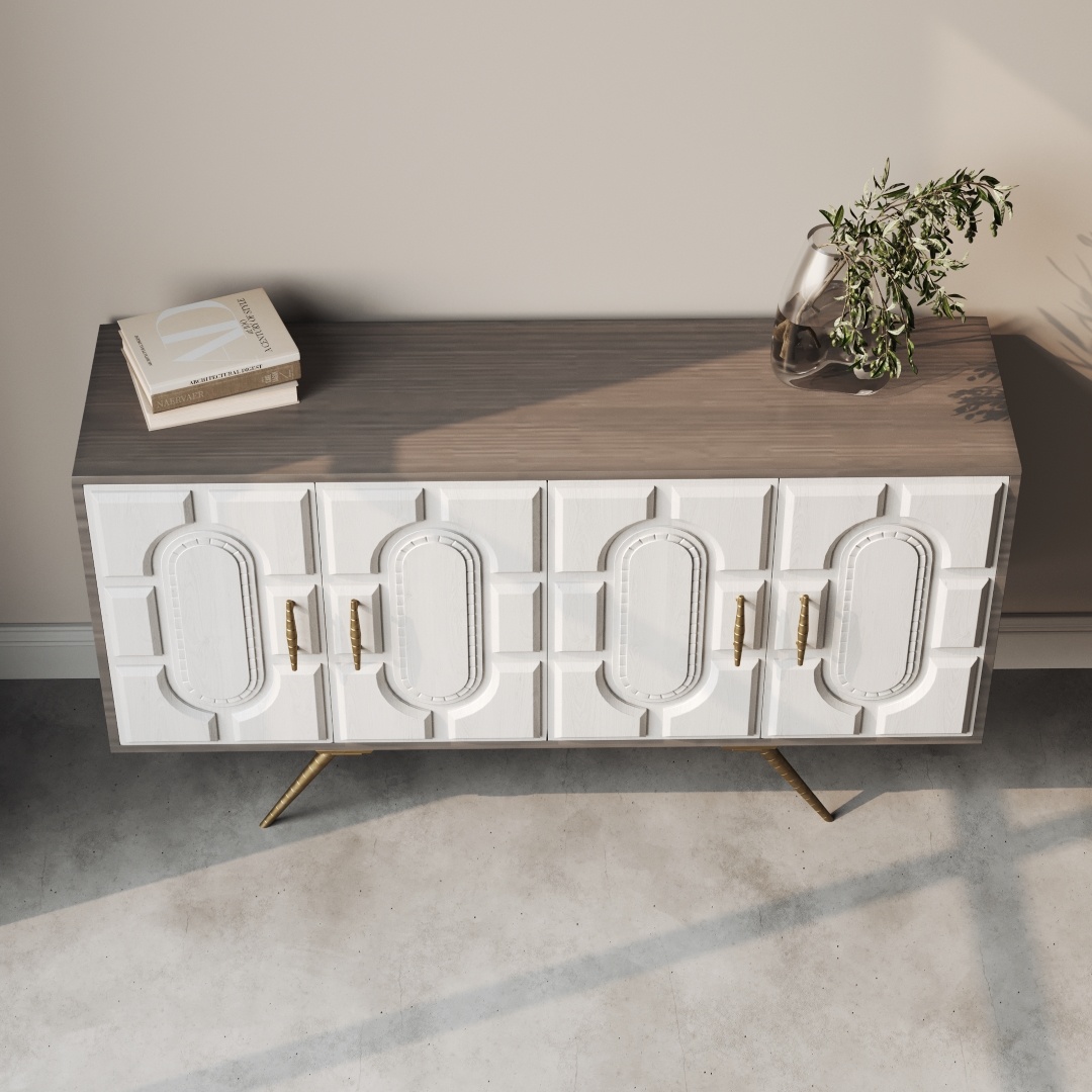 Lugo 60 Side Cabinet-d The Lugo 60" Sideboard features a wooden construction with a textured white front, brass handles, and angled legs. It is topped with a gray surface that holds a book and a vase containing a small plant.