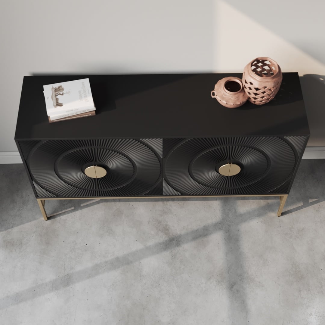 Orbita 60 Side Cabinet-d The Orbita 60" Sideboard features black doors with a striking radial pattern, complemented by gold handles and legs. It is styled with a stack of books and two ceramic vases on top, creating an elegant contrast against a light wall on a concrete floor.