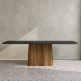 An Osaka Dining Table, featuring a modern black rectangular top and a ribbed wooden pedestal base, is placed against a light-colored wall on a terrazzo floor.