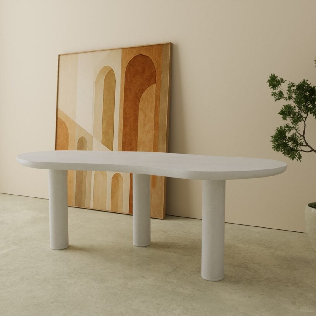 87 Aero Organic Dining Table in white 2 A minimalist room featuring the Aero Organic Dining Tableโa white, three-legged oval tableโpaired with a large abstract arch painting leaning against the wall and a potted plant on the right.
