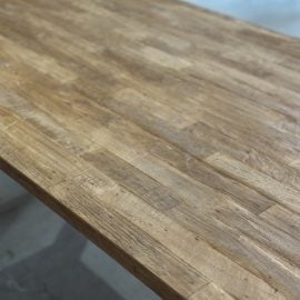 A close-up view of the Metal Dining Table (Natural) showcasing its natural grain pattern in a well-lit indoor setting.