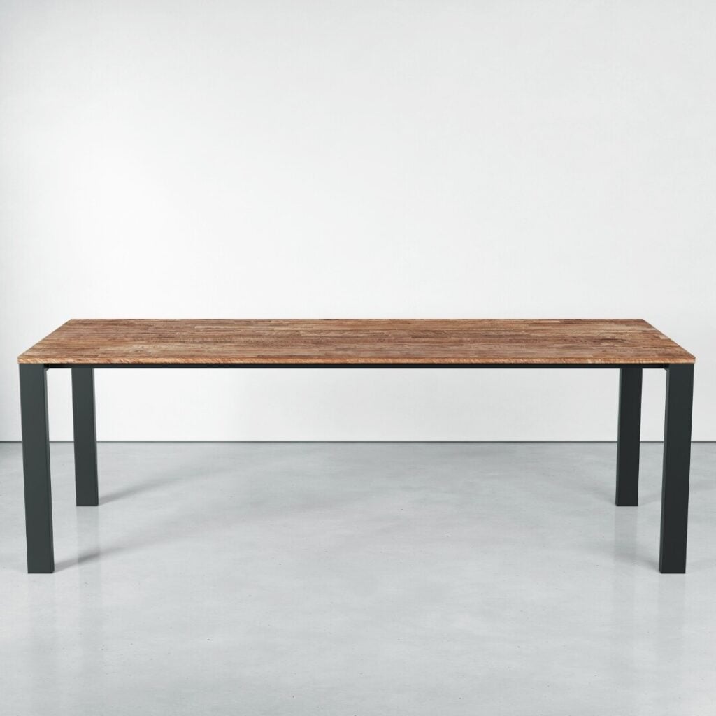 A Metal Dining Table (Natural) with a light brown surface and black legs stands on a gray floor against a white wall.