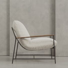 The Aspen 30" Lounge Chair features a white textured cushion, black metal frame, and wooden armrests, shown against a gray concrete wall.