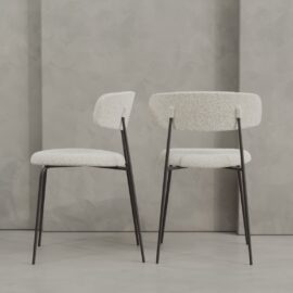 Two Alto 20" Dining Chairs (Metal) with white textured upholstery and black metal legs are placed side by side against a gray textured wall.