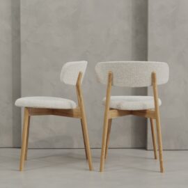 Two Alto 20" Dining Chairs (Wood) with light wood frames and white upholstered seats and backs, placed on a smooth floor against a textured gray wall.