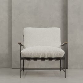 The Aspen 30" Lounge Chair features white textured upholstery, a sleek metal frame, wooden armrests, and a minimalist silhouette, styled here against a gray textured wall.