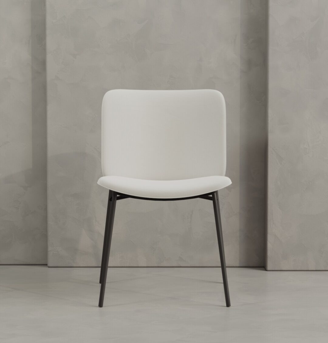 3 Kora The Kora 20" Dining Chair features modern white upholstery and black metal legs, shown against a light gray textured wall.