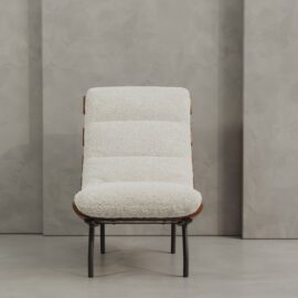 The Oslo 24" Lounge Chair features a textured white cushion and sleek black metal legs, showcased against a gray textured wall and floor.
