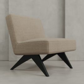 The Laurel 27" Lounge Chair, upholstered in beige with angled black wooden legs, sits on a light gray floor against a textured gray wall.