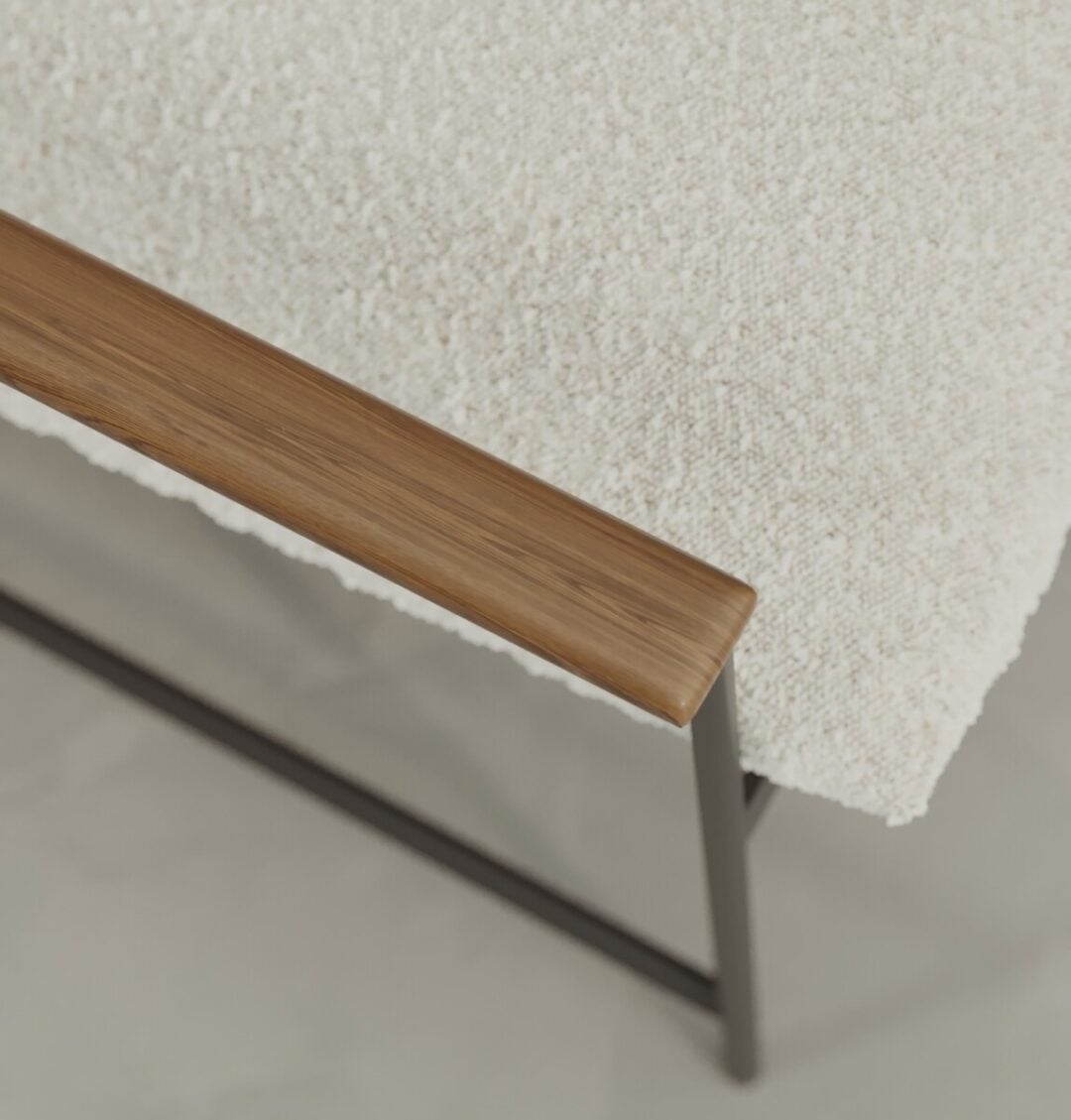 5 Aspen Close-up of the Aspen 30" Lounge Chair featuring a textured white cushion, wooden armrest, and black metal frame on a light-colored floor.