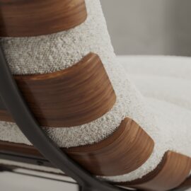 Close-up of the Oslo 24" Lounge Chair with curved wooden slats, textured cream upholstery, and a metal frame on the side.