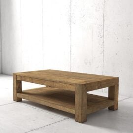 A rectangular wooden coffee table with thick legs and a lower shelf, set against a white concrete wall and floor.