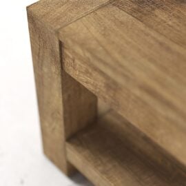 Close-up of the corner of a wooden table or shelf, showing its grain texture and right-angled design.