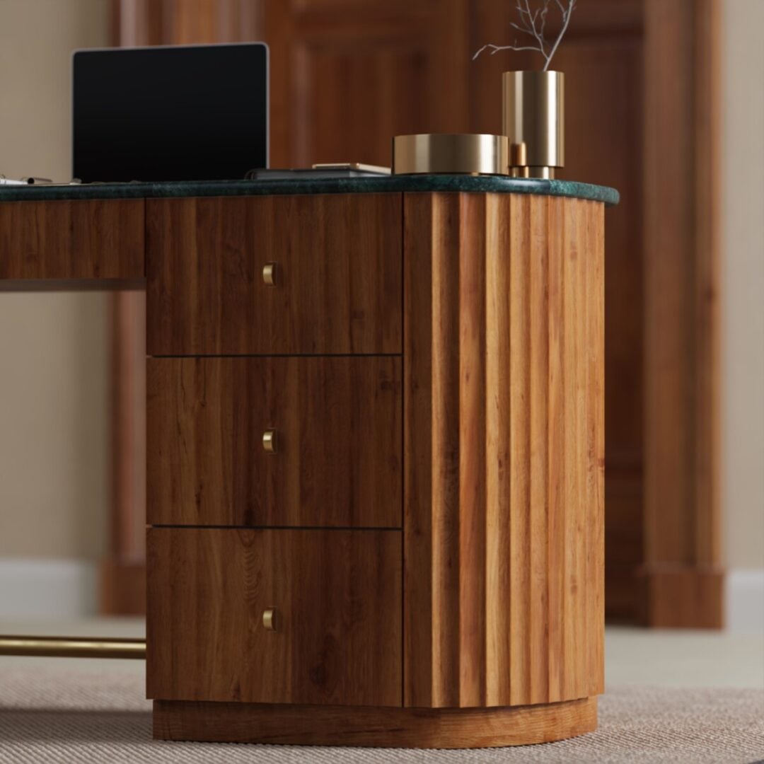 Elma 53-in. Desk-04 Close-up of the Elma Desk, a wooden piece with three drawers and gold handles, topped with decorative gold vases; part of a laptop and some books are also visible.