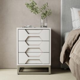 The Vexa Nightstand, with modern white geometric drawer fronts, stands by the bed; a glass vase with green branches and a pair of glasses sit on top.