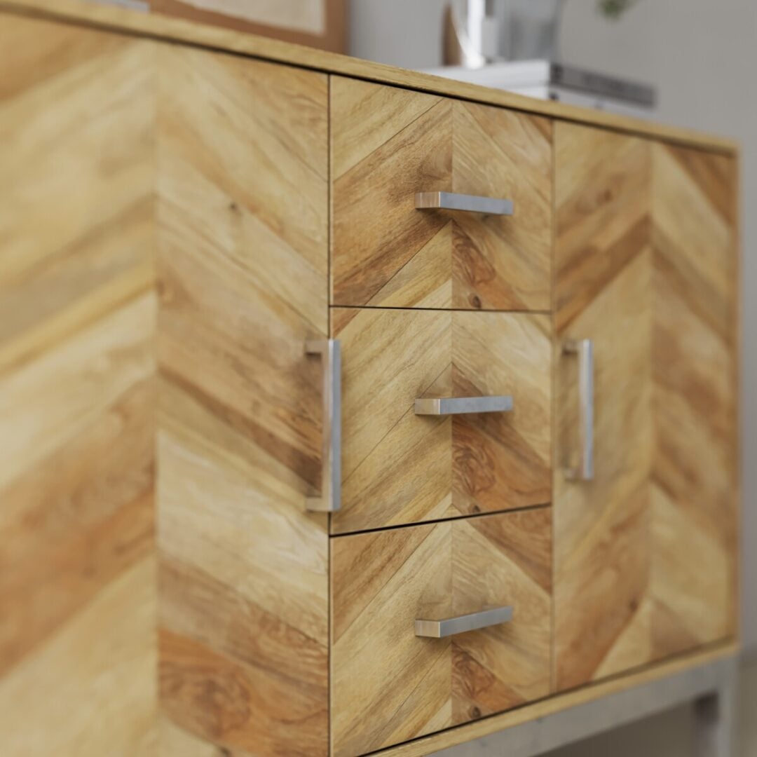 Zera 56in. Sideboard-02 Close-up of the Zera Sideboard, a wooden cabinet with a chevron pattern, featuring three central drawers and two side doors with silver handles.