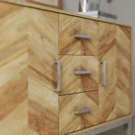 Close-up of the Zera Sideboard, a wooden cabinet with a chevron pattern, featuring three central drawers and two side doors with silver handles.