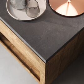 A close-up of the Nox Nightstand with a dark stone top, featuring two glass cups, a tray, and part of a copper-colored lid.